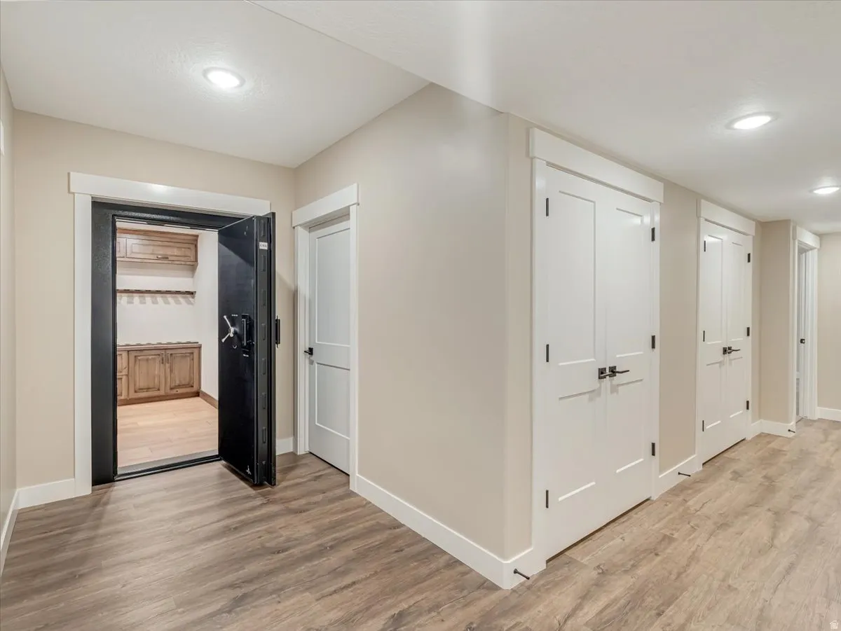Entryway featuring wood-finish flooring, recessed lighting, and a vault door