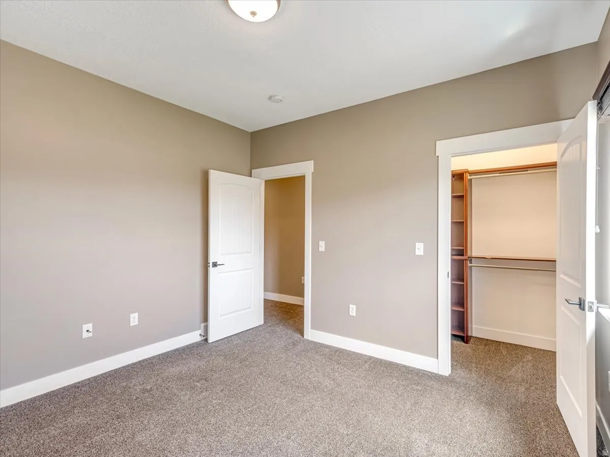 Spacious room featuring neutral carpeting, light neutral wall paint, and bright white trim