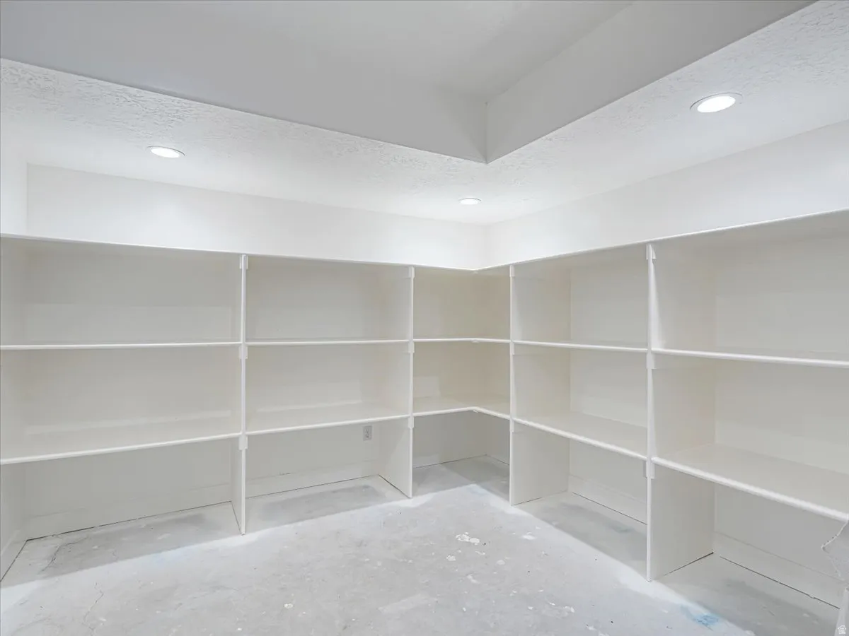 Corner-oriented shelving system featuring multiple levels of white-finished shelving