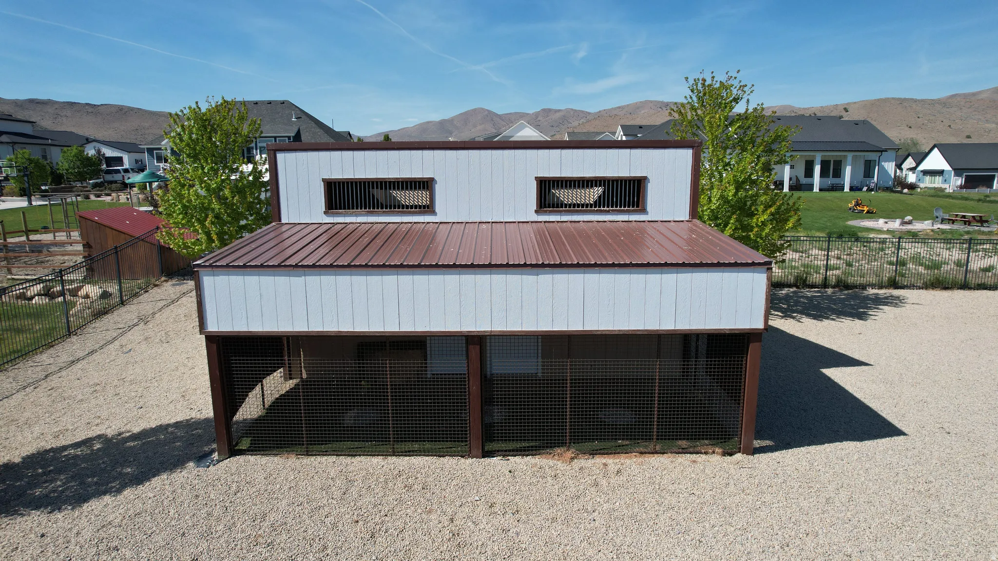 Detached outbuilding featuring a metal roof and light-colored siding