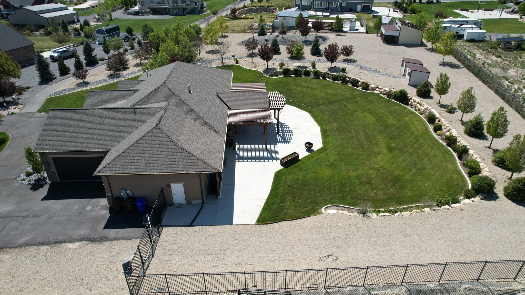 Expansive rear yard featuring a manicured lawn, concrete patio, and pergola