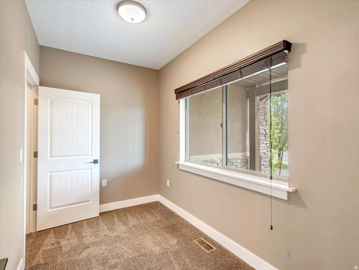 Neutral tone walls featuring white trim and a single window with blinds