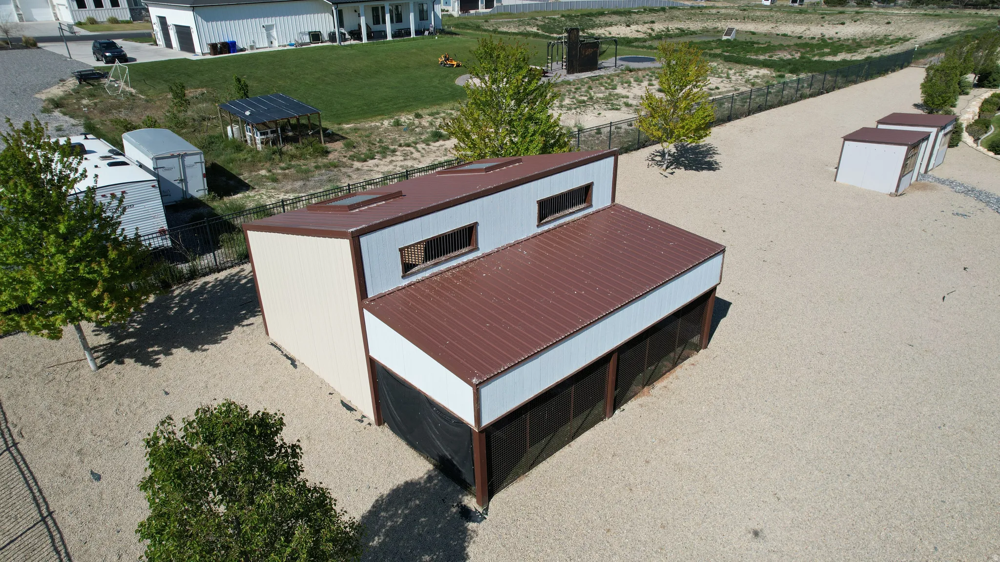 Metal outbuilding featuring a brown metal roof, light-colored siding, and multiple skylights