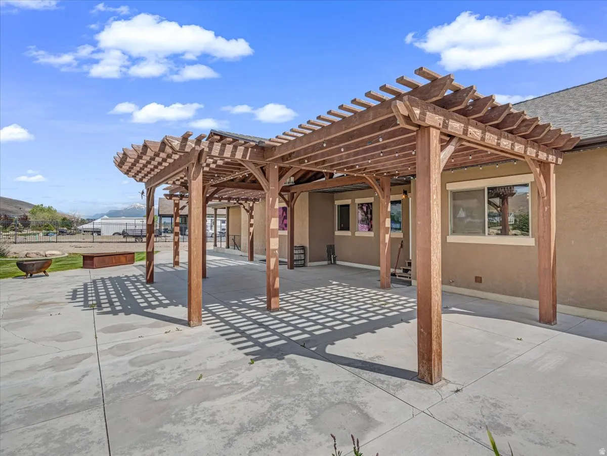 Expansive concrete patio featuring multiple wooden pergolas