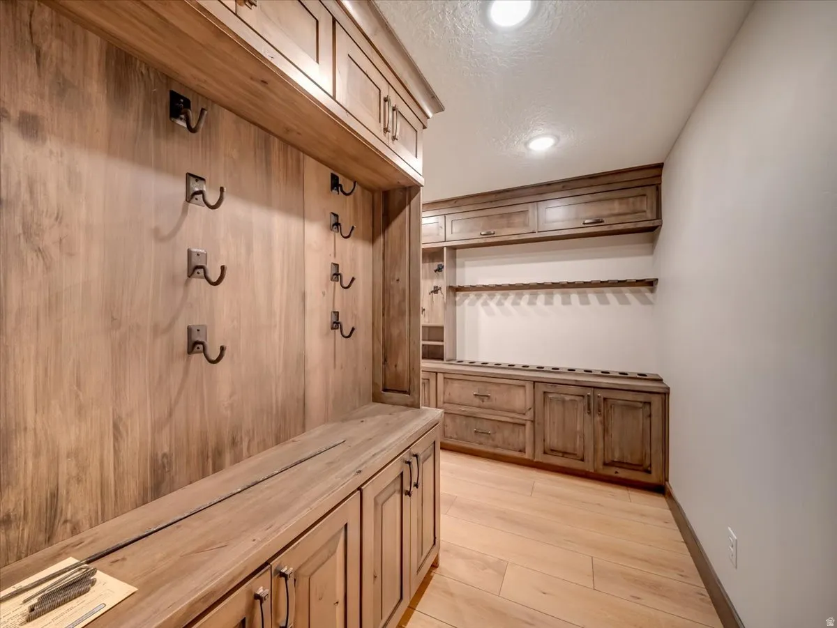Built-in wood-finish cabinetry and shelving with integrated coat hooks and dedicated storage