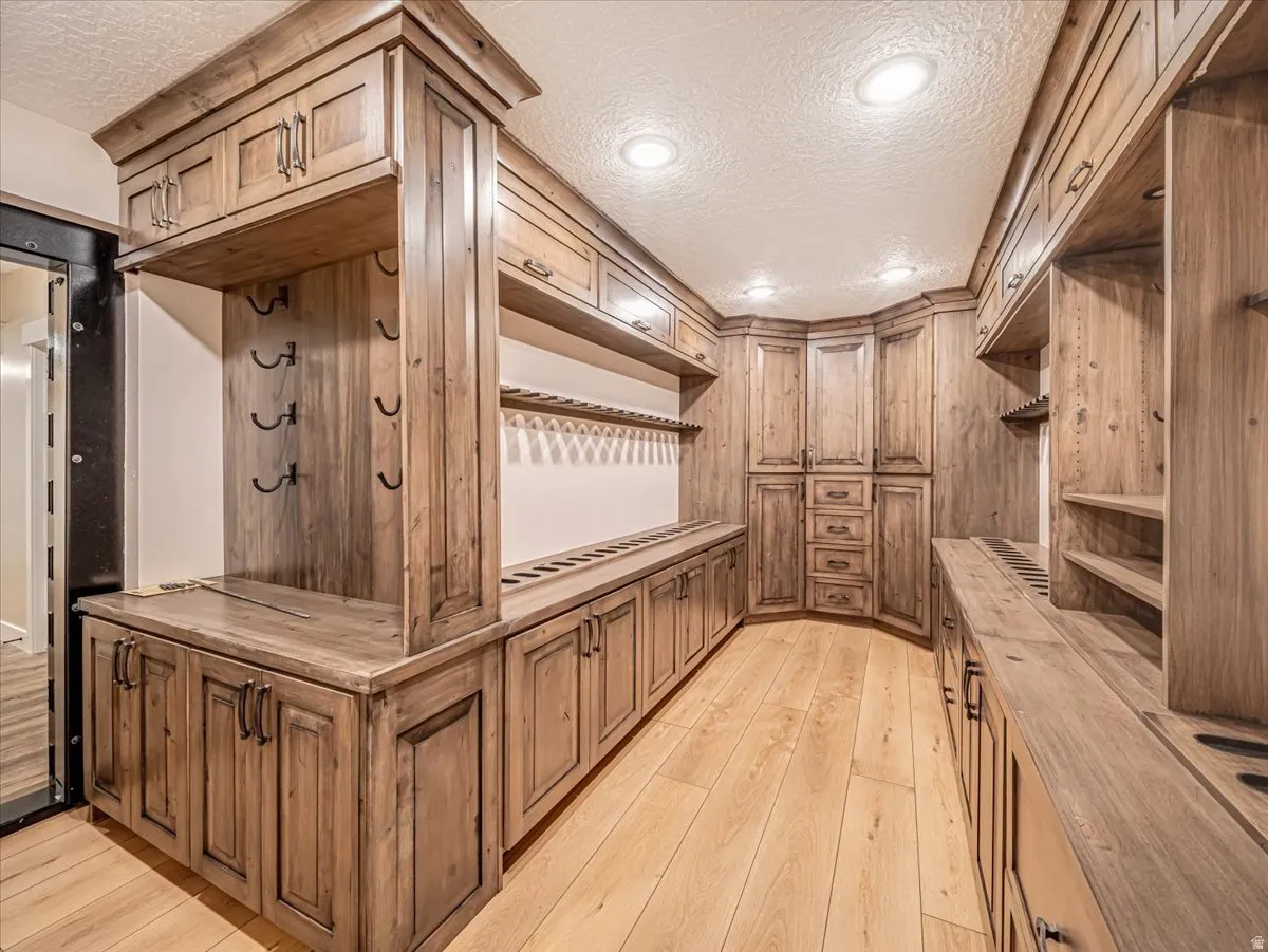 Custom wood-finish cabinetry featuring integrated shelving, built-in storage, recessed lighting, and wood-finish flooring