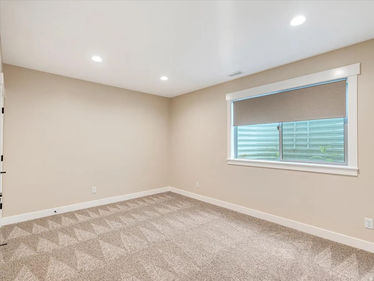 Room featuring light tan walls and patterned carpeting