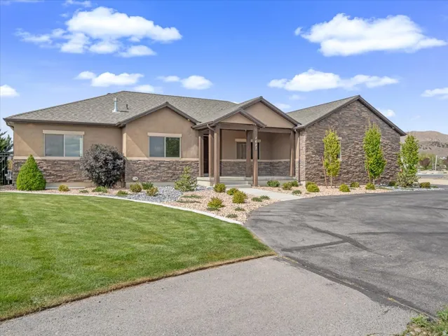 Ranch-style residence featuring a prominent stone facade and stucco exterior
