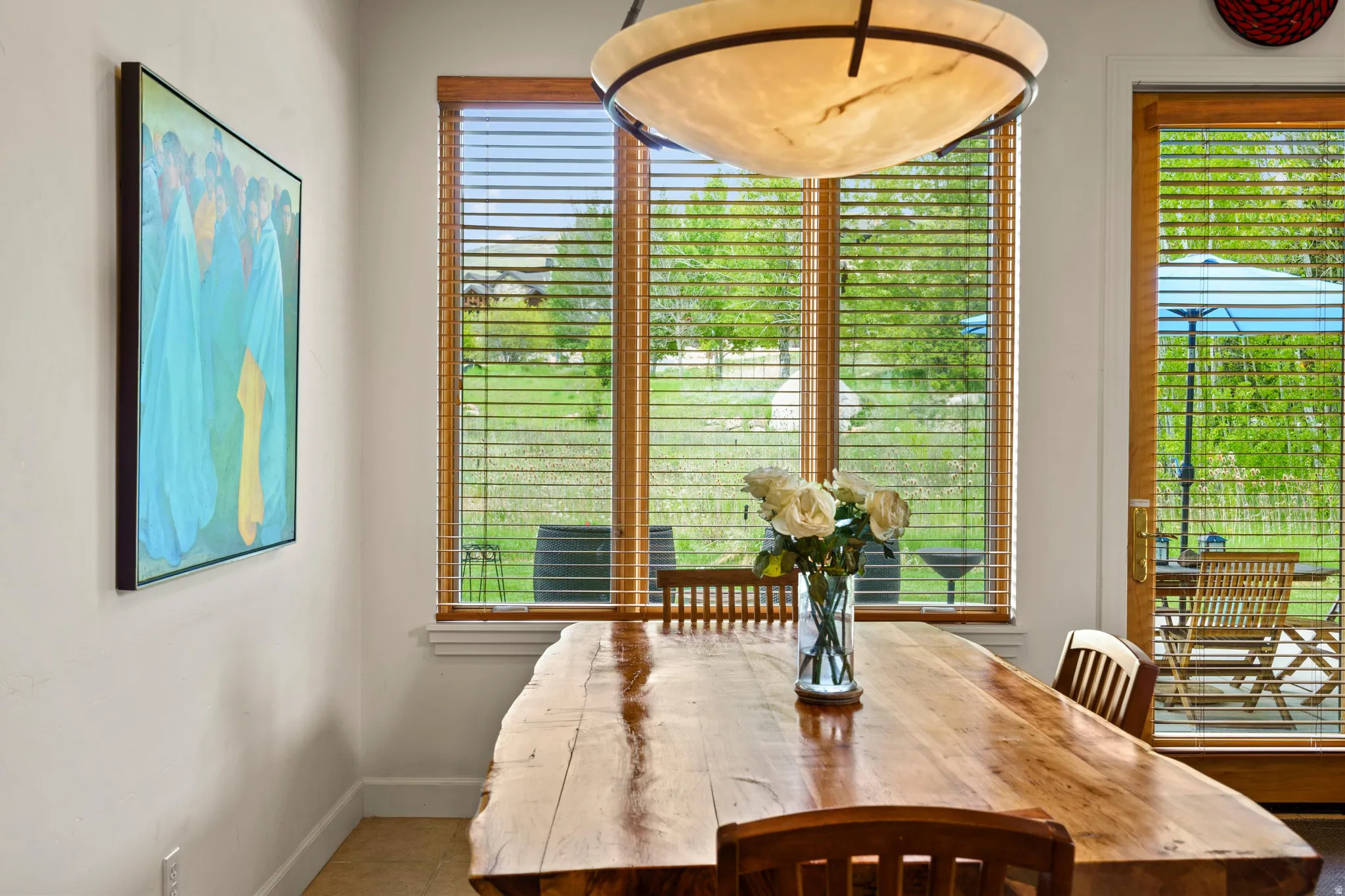 Hardwood dining table with natural edge, accompanied by wooden chairs