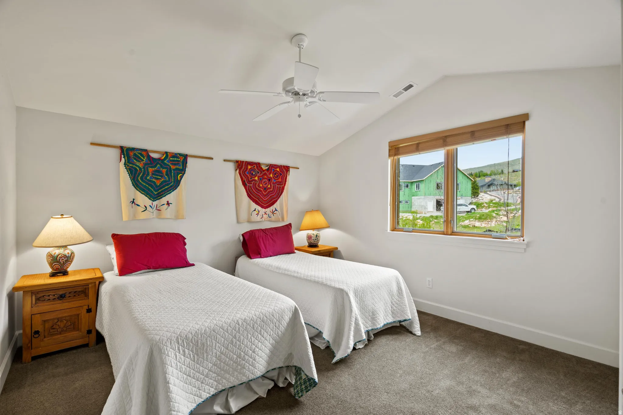 Room featuring a vaulted ceiling, white walls, and gray carpet