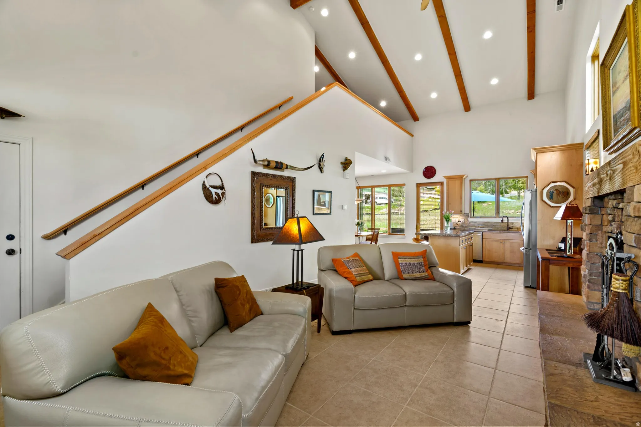 Living area with vaulted ceilings, exposed wood beams, and recessed lighting