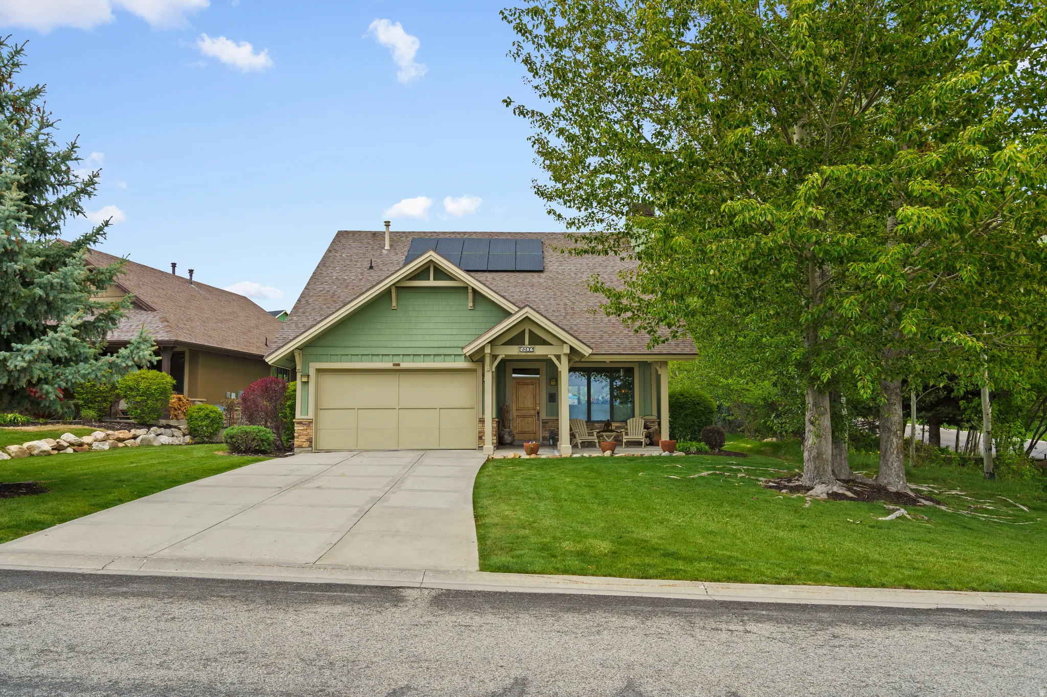 Ranch-style residence featuring a prominent front gable, a two-car garage, and a covered front porch