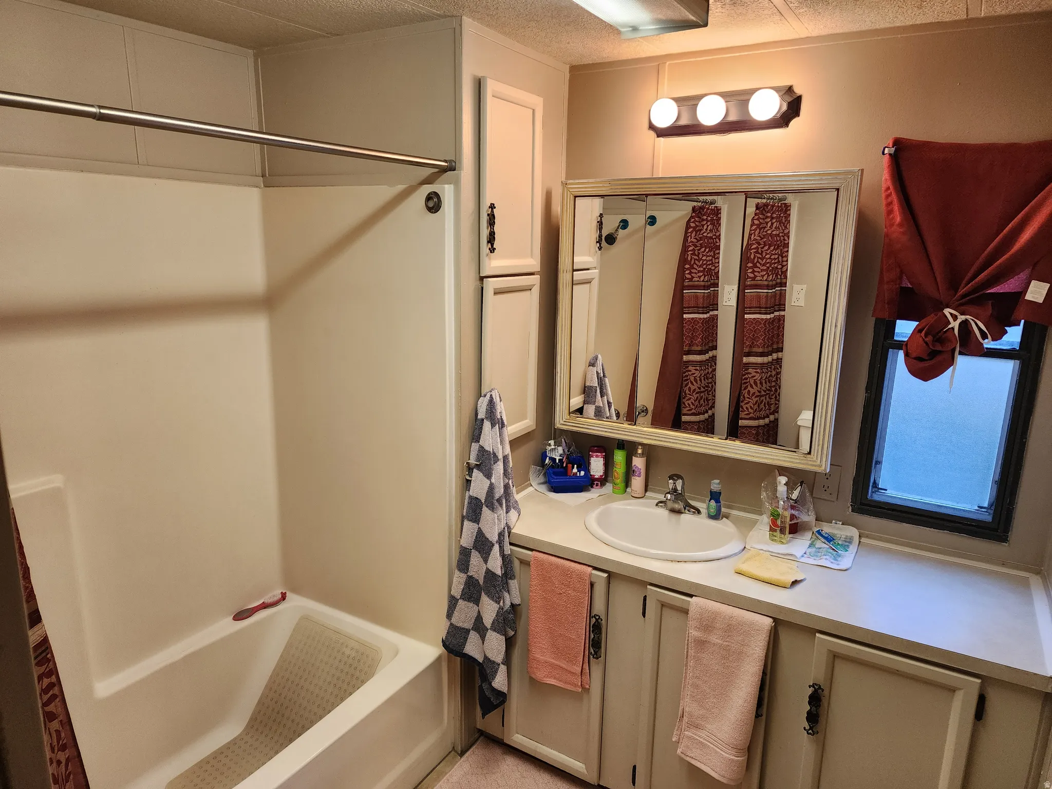 Bathroom featuring an integrated tub and shower with a chrome rod