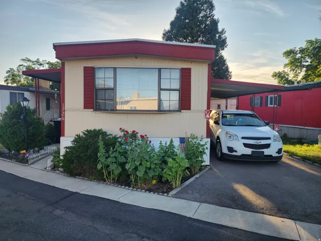 Exterior featuring a red metal roof and cream siding