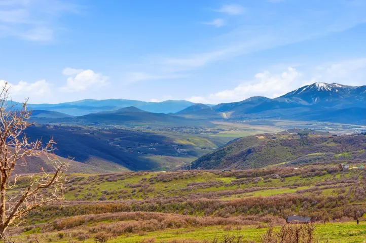 Expansive mountain landscape featuring varied elevations and distant snow-capped peaks