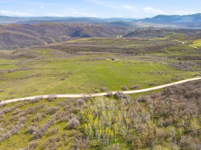 Expansive natural landscape featuring rolling hills and distant mountains