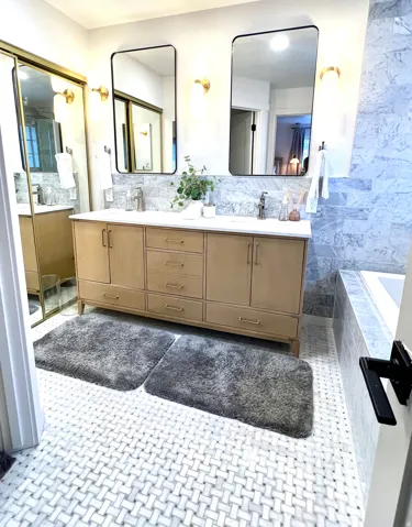 Double vanity with natural wood-finish cabinetry and brushed gold hardware