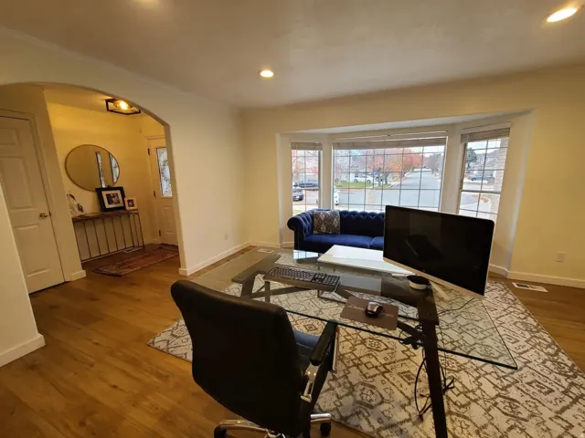 Expansive front room featuring wood-finish flooring and a large bay window