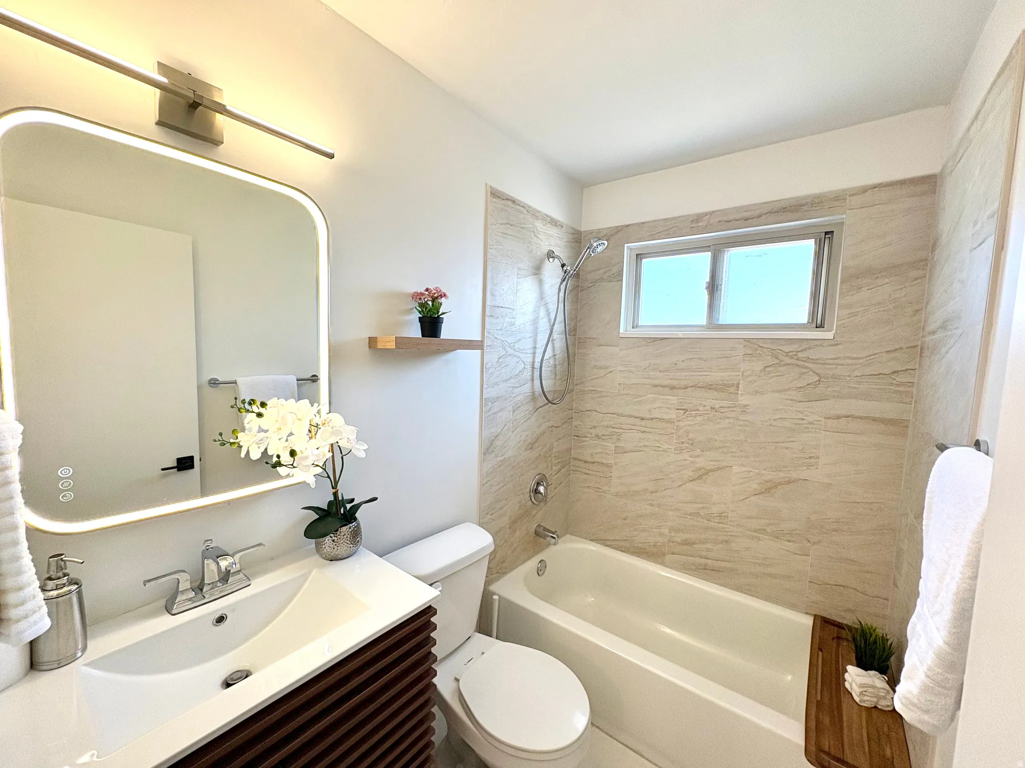 Bathroom featuring a rectangular vanity with a white countertop, chrome faucet, and a light-framed mirror