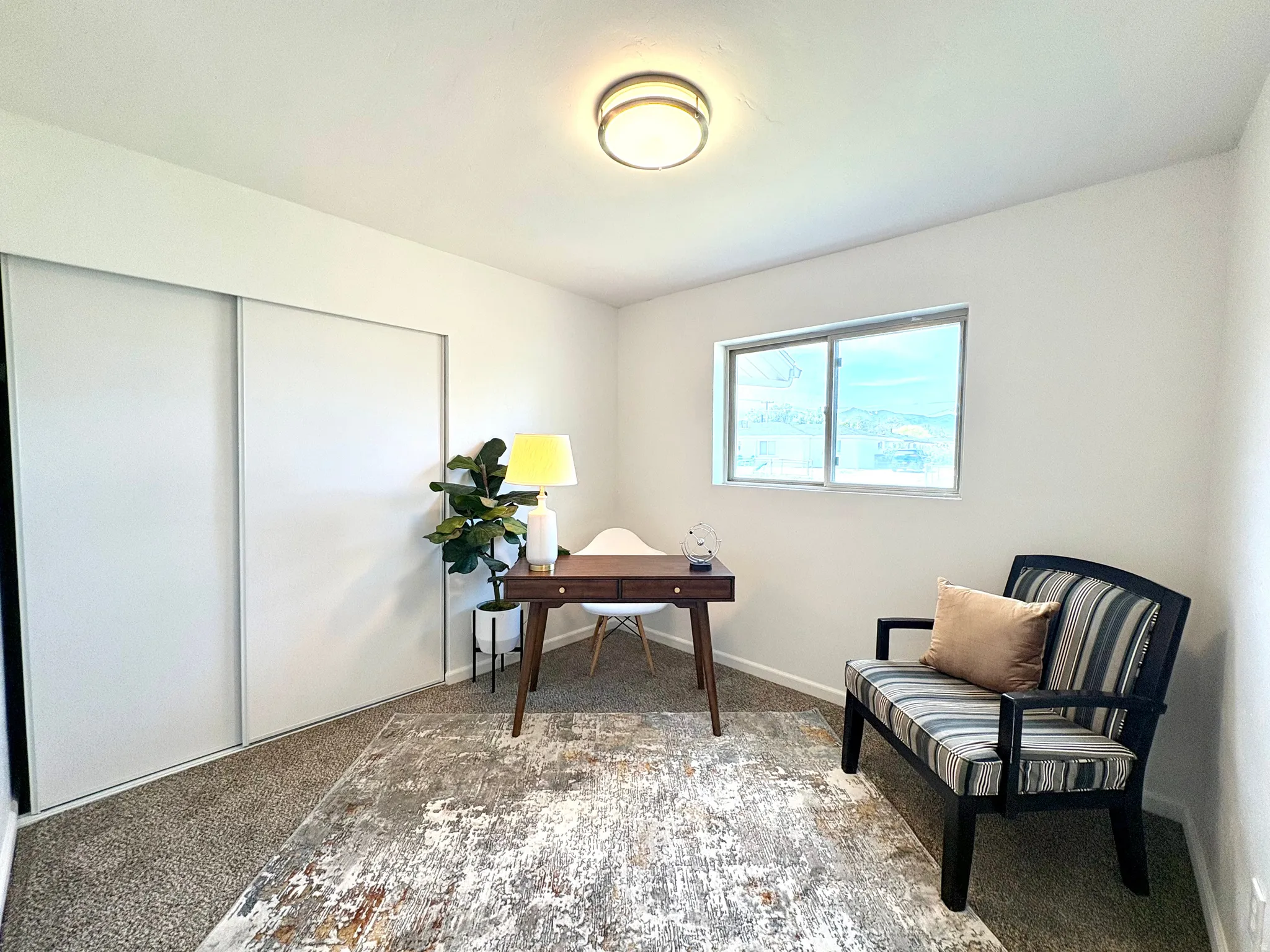 Room featuring a window, neutral wall paint, and sliding closet doors