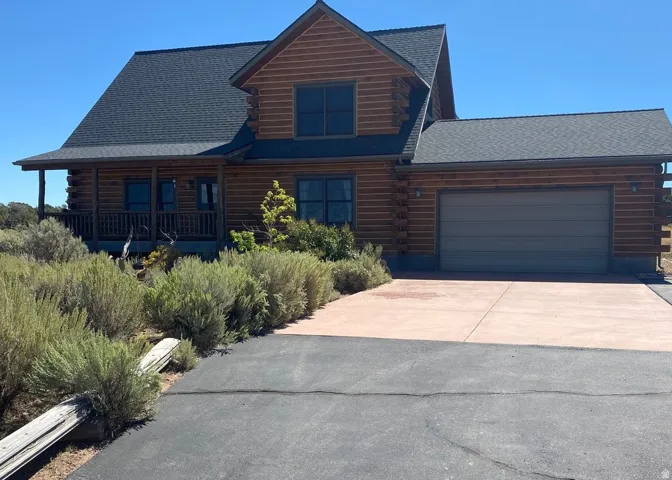Log cabin-style residence featuring a prominent attached garage