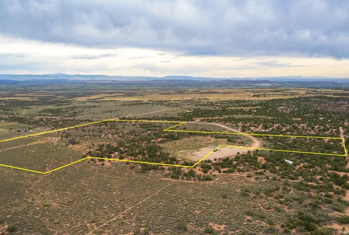 Expansive undeveloped land featuring natural terrain with scattered brush and trees