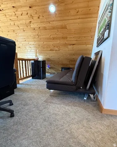 Attic space featuring wood plank paneling, recessed lighting, and light gray carpeting