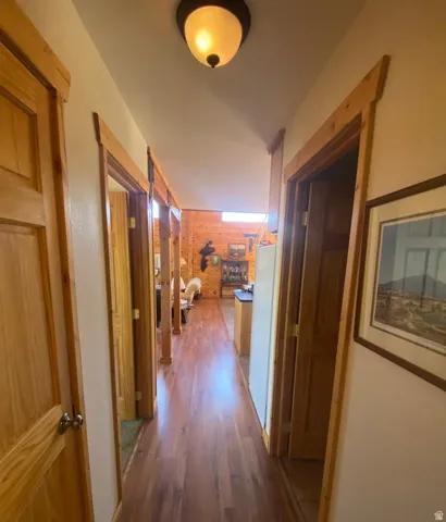 Hallway featuring wood-finish flooring and solid wood doors