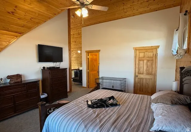 Vaulted ceiling featuring wood-finish paneling and a ceiling fan with light fixture
