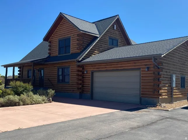 Log-style exterior featuring a prominent two-car garage
