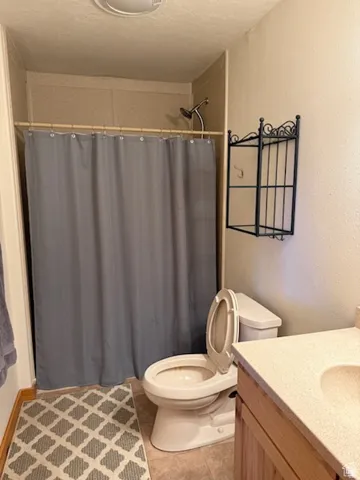 Shower-over-tub combination with a wall-mounted showerhead, adjacent to a vanity with integrated sink and countertop