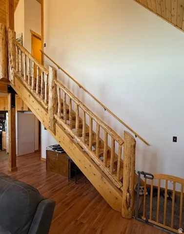 Natural wood staircase featuring rustic log newel posts and spindles