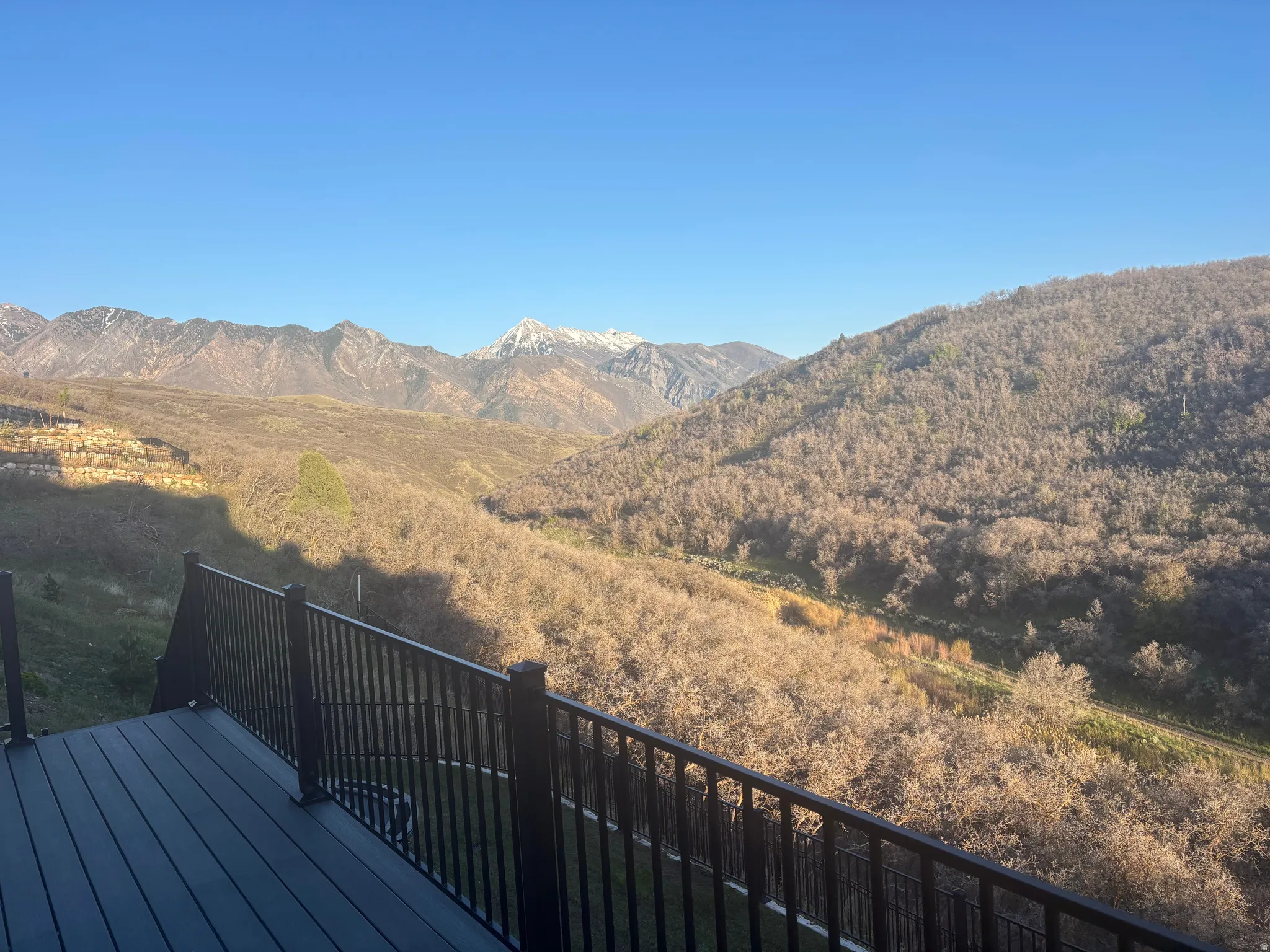 Expansive composite deck featuring a black railing system and mountain scenery