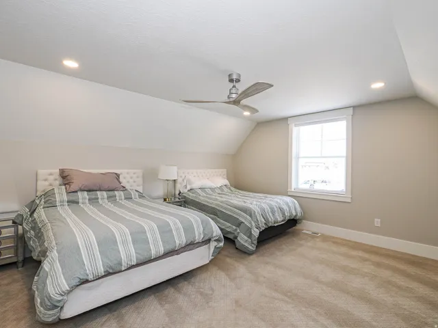 Carpeted room with sloped ceilings and recessed lighting