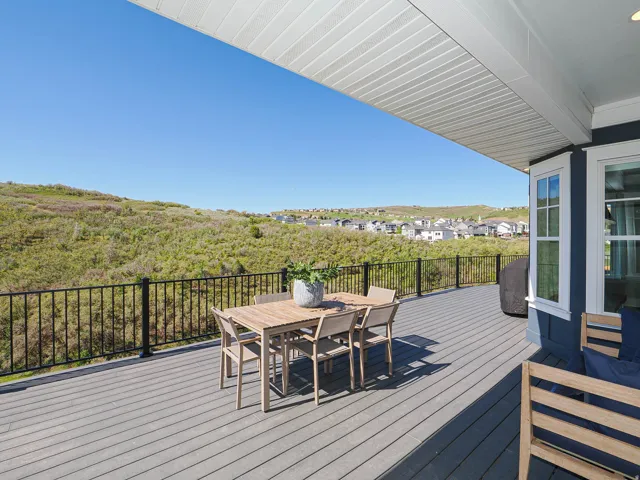 Expansive composite deck featuring black metal railings and a substantial covered patio ceiling