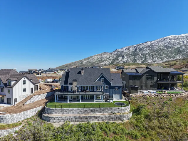Multi-level residence featuring a dark blue facade and dark shingle roofing