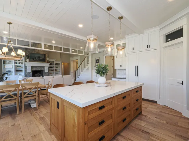 Spacious kitchen island with a white veined countertop and wood-finish cabinetry