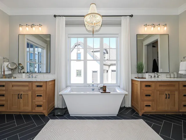 Freestanding soaking tub centered under a large multi-pane window