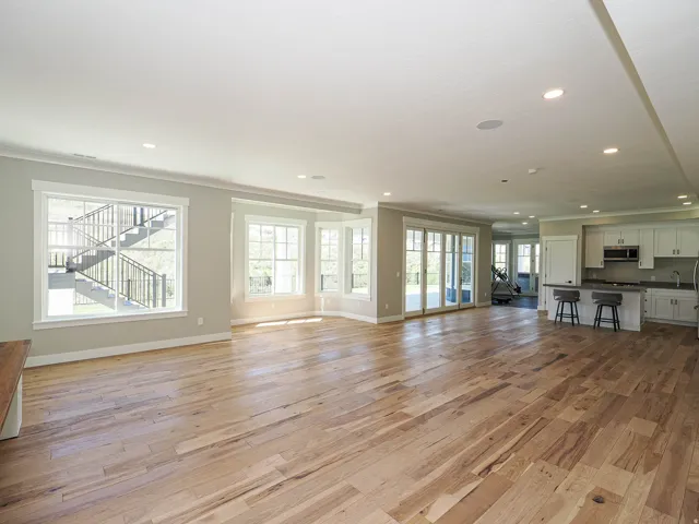 Expansive great room featuring wide plank wood-finish flooring, recessed lighting, and multiple windows