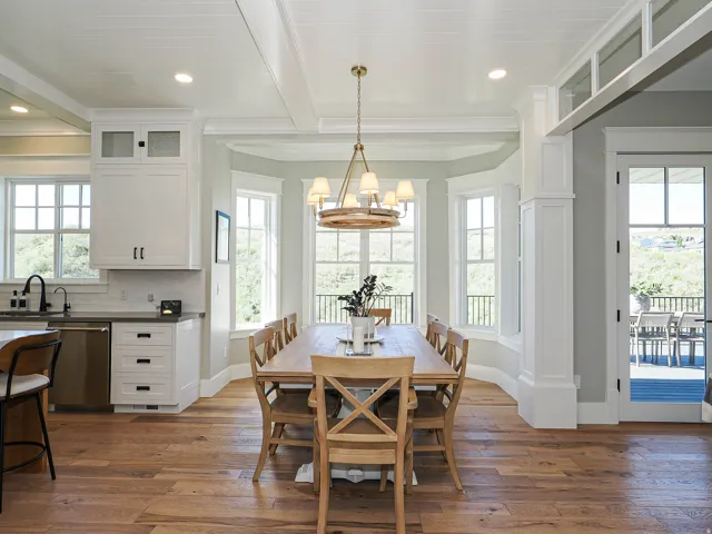 Spacious dining area featuring wood-finish flooring, a coffered ceiling, and a large bay window