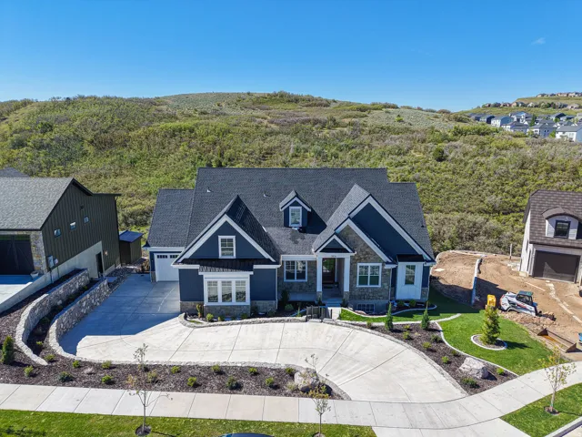 Modern traditional residence featuring a multi-gabled roofline and a stone and siding exterior