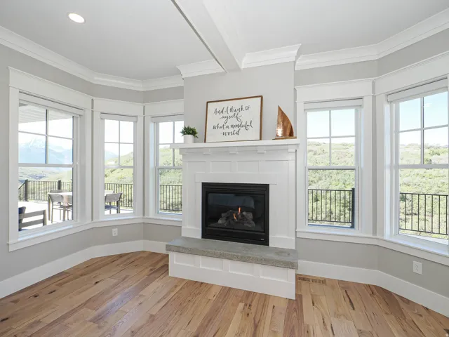 Fireplace with a white mantel and hearth, flanked by multiple windows