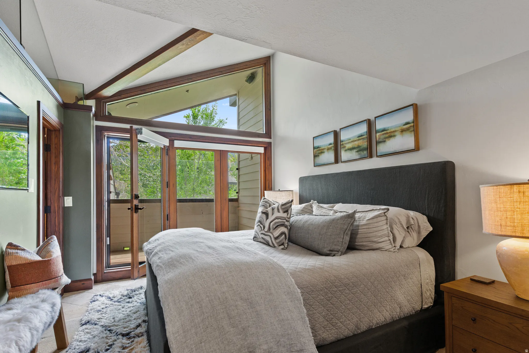 Bedroom featuring expansive glass doors, wood-frame windows, and a private balcony