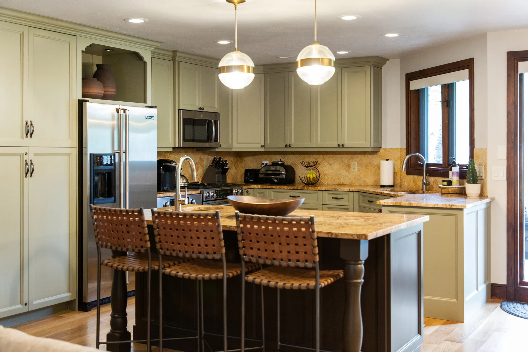 Kitchen featuring light-toned cabinetry, stainless steel appliances, and a central island with granite countertops