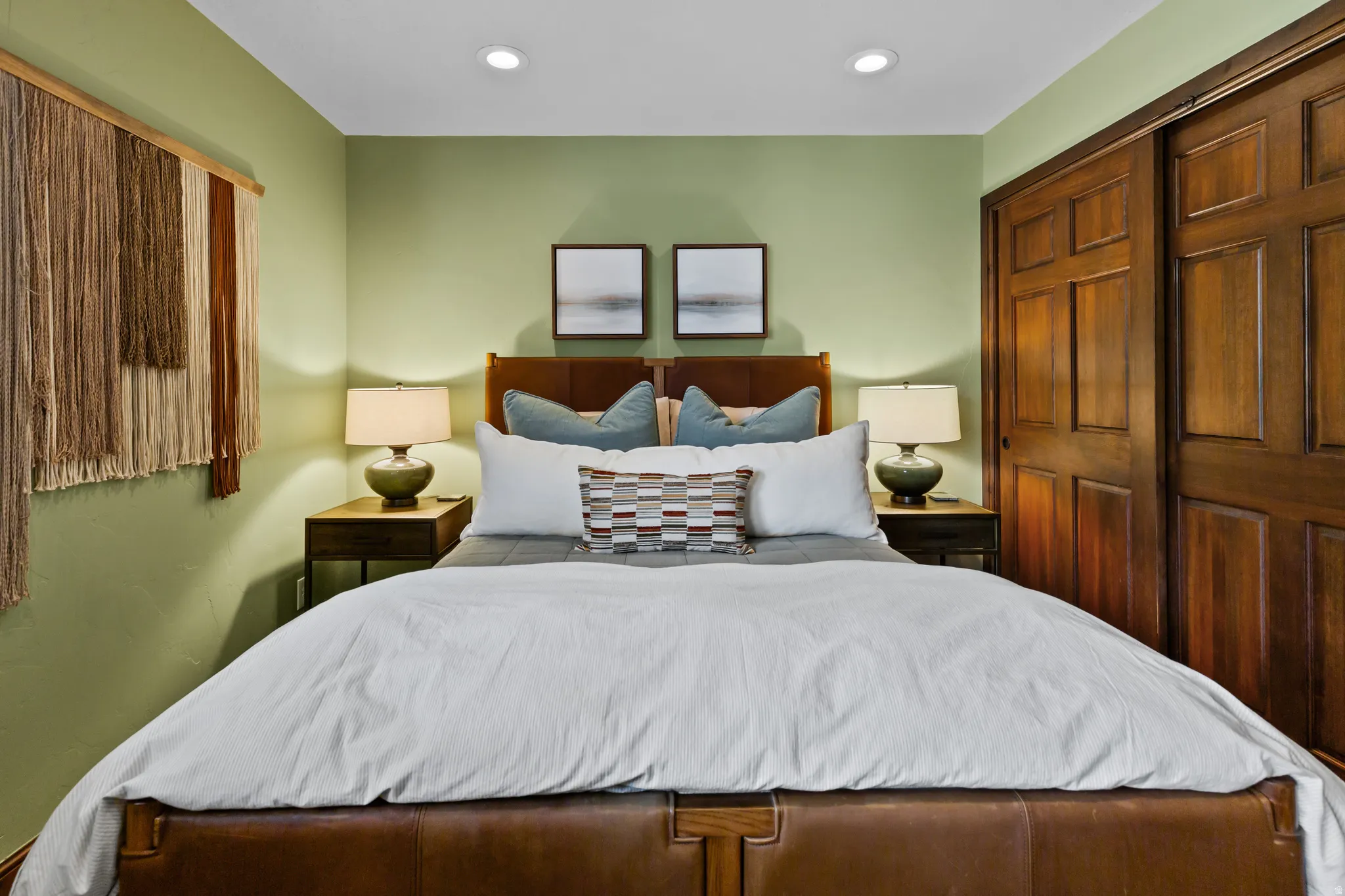 Bedroom featuring recessed lighting, a paneled wood headboard, and a matching wood-finish nightstand