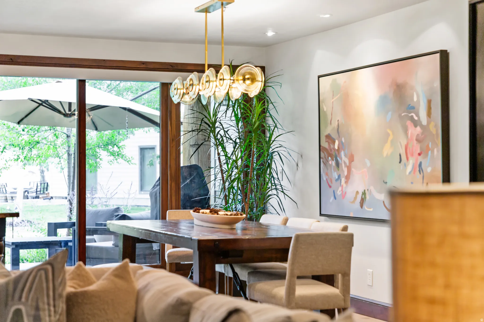 Contemporary dining area featuring a linear chandelier with clear glass shades