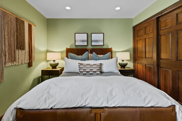 Bedroom featuring recessed lighting, a paneled wood headboard, and a matching wood-finish nightstand