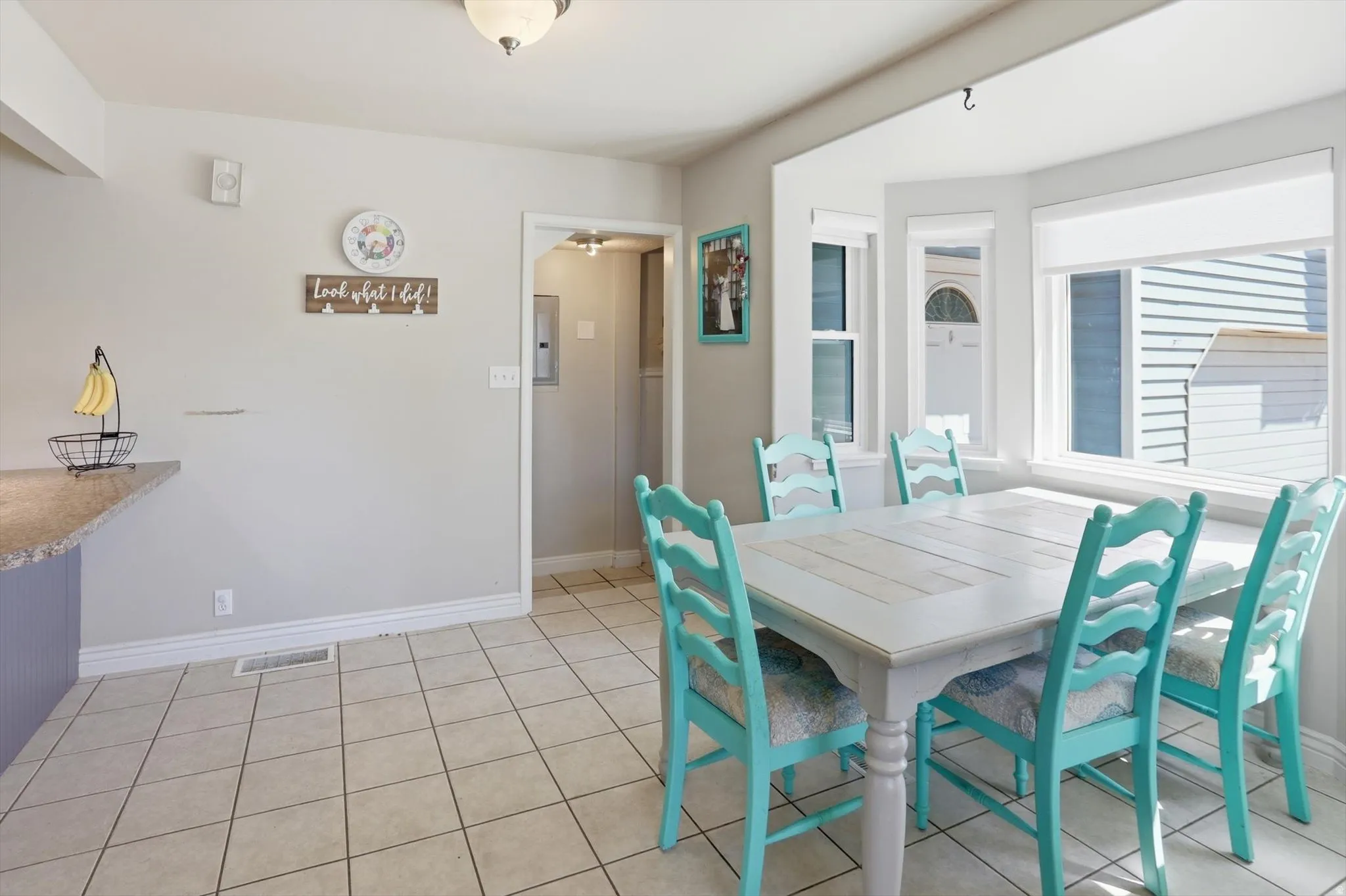Dining area featuring a bay window with multiple panes, tile flooring, and light-toned walls