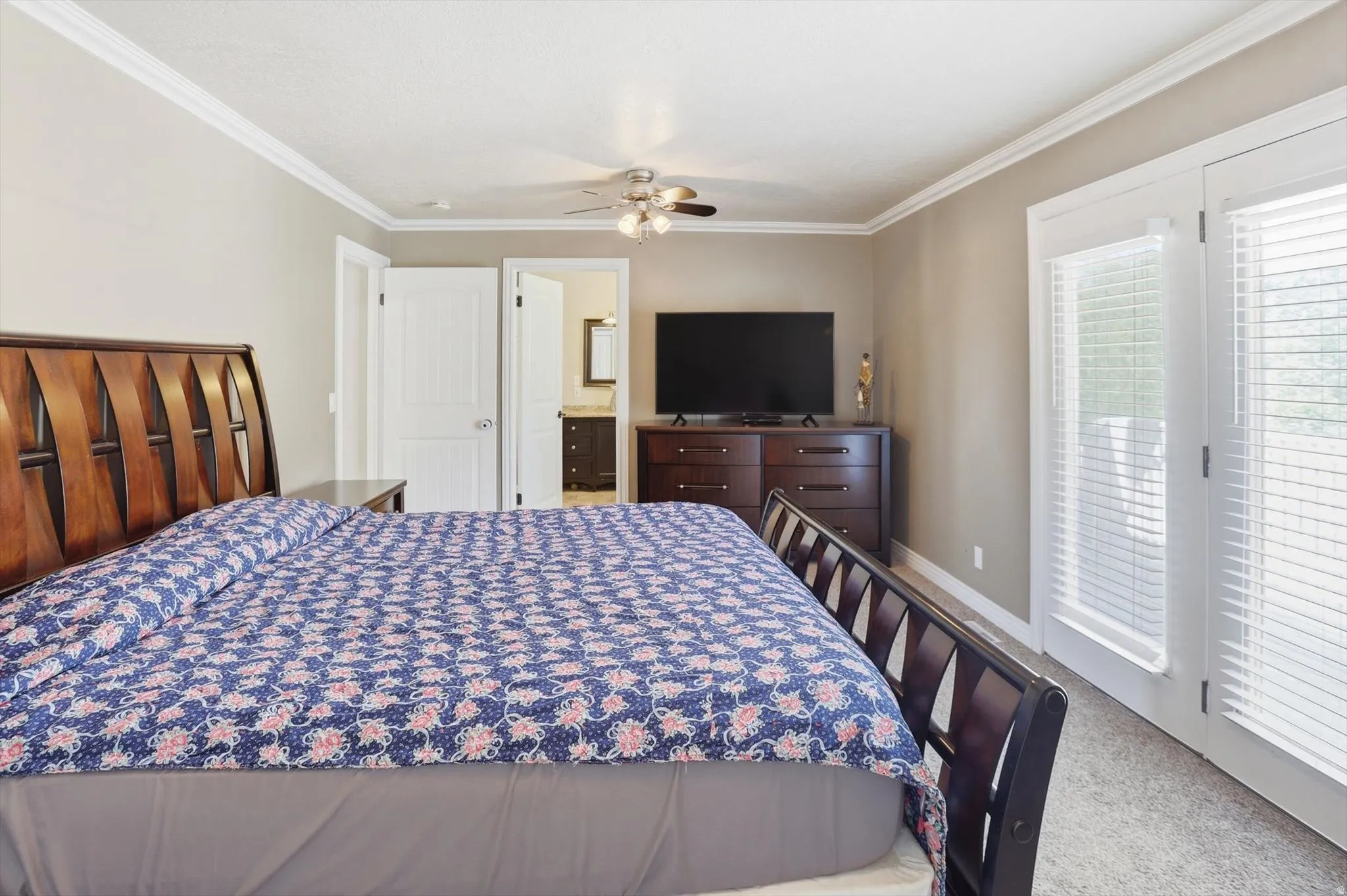 Bedroom featuring crown molding, carpet flooring, a ceiling fan, and French doors with blinds