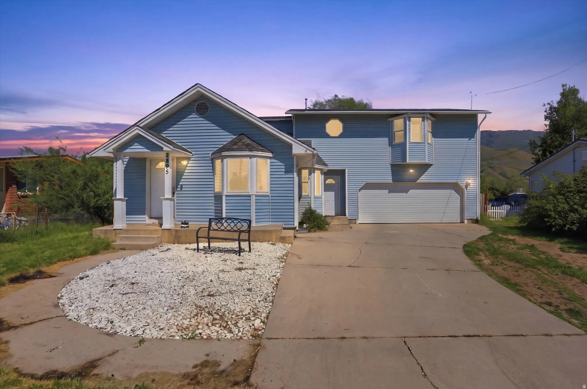 Two-story residence featuring light blue siding, a two-car garage, and a concrete driveway